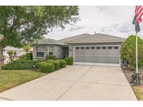 Charming home featuring a gray exterior, well-manicured lawn, and an attached two-car garage at 9107 Sw 102Nd Cir, Ocala, FL 34481
