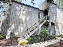 Two-story townhouse with wood siding and stairs leading to the front door at 211 Crown Oaks Way, Longwood, FL 32779