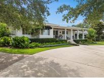 Charming home featuring a landscaped front yard, covered porch and a circular driveway at 1410 Poinsettia Ave, Orlando, FL 32804