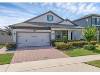 Beautiful home featuring a brick driveway and a well-maintained front yard with lush landscaping at 1896 Napoli Dr, St Cloud, FL 34771