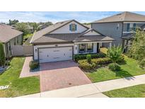 Charming single-Gathering home featuring a 2-car garage, landscaped yard, and covered porch at 1896 Napoli Dr, St Cloud, FL 34771