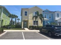 Charming two-story home with palm trees and a modern parked car at 3069 Caribbean Soul Dr, Kissimmee, FL 34747