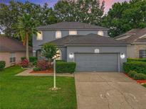 Charming gray two-story home featuring a well-manicured lawn and a spacious two-car garage at 9525 Southern Garden Cir, Altamonte Springs, FL 32714