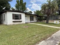 Charming one-story home featuring a well-manicured front yard with mature palm tree at 2448 Austin Ave, Deltona, FL 32738