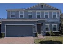 Charming two-story home boasts a well-maintained lawn and a convenient two-car garage at 1710 Summer Rose Dr, Mount Dora, FL 32757