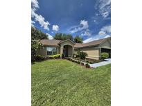 Charming single-story home with well-manicured lawn, landscaping, and blue driveway at 15917 Mercott Ct, Clermont, FL 34714