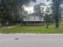 Charming two-story home featuring a well-maintained lawn and mature trees at 5641 Nw 55Th Ave, Ocala, FL 34482