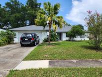 Charming single-story home with a well-maintained lawn and mature landscaping, and a modern SUV parked in the driveway at 5523 Westview Dr, Orlando, FL 32810