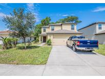 Charming two-story home featuring a spacious driveway and well-maintained lawn with a blue pickup truck at 938 Mansfield Rd, Tavares, FL 32778