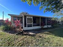 Charming single-story home with a screened-in porch and well-maintained landscaping at 4395 E Michigan St # 4395, Orlando, FL 32812