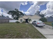 Charming single-story home with a well-manicured lawn, attached garage, and traditional architectural details at 2921 Blackburn Ave, Deltona, FL 32738