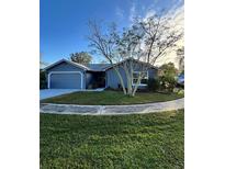 Cute one-story house with a two-car garage and well-maintained lawn at 1083 Sunshine Sw Way, Winter Haven, FL 33880