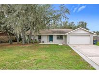 Charming single-story house with a blue front door and a large yard at 4201 Shadow Wood Dr, Winter Haven, FL 33880