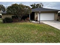 Ranch style home with a well-manicured lawn and attached garage at 2062 Katie Ct, Winter Haven, FL 33884