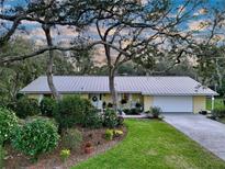 Charming home featuring a metal roof, mature landscaping, and a welcoming front porch at 41 Spring Ln, Haines City, FL 33844