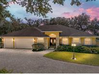 Beautiful home with three-car garage and landscaped yard at dusk at 465 Rowland Ct, Bartow, FL 33830