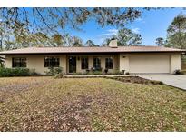 Charming single-story home featuring a well-maintained lawn, mature trees and inviting facade at 7929 Chase Rd, Lakeland, FL 33810