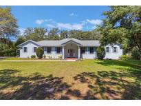 Charming single-story home with a well-manicured lawn and blue shutters at 1131 Country Oaks Blvd, Lake Wales, FL 33898