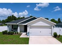 Well-maintained single-Gathering home featuring an attached two-car garage and manicured lawn at 1205 Third Ct, Eagle Lake, FL 33839