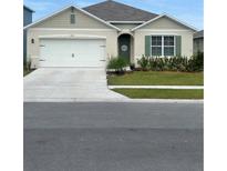 Charming single-story home with a well-manicured lawn, a two-car garage, and neutral paint at 1414 Fox Squirrel Dr, Davenport, FL 33897