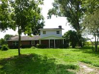 Charming two-story home featuring a brick facade, inviting front porch, and mature trees at 1835 Mount Pisgah Rd, Fort Meade, FL 33841