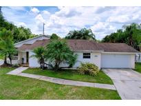 Charming single-story home with lush landscaping and attached two-car garage at 4966 Foxrun Ln, Lakeland, FL 33813