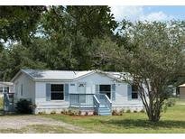 Charming single-story home with a light blue painted porch, matching shutters, and a well-maintained lawn at 5217 Turtle Dove Trl, Lakeland, FL 33810