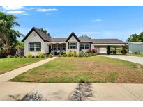 Charming two-story home with landscaped yard, bright white exterior, and covered carport at 733 S Clayton Ave, Lakeland, FL 33801