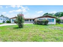 Charming single-story home featuring a metal roof, green shutters, and lush front yard at 900 Howard Nw Ter, Winter Haven, FL 33881