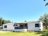 Charming single-story home with a front porch and well-maintained lawn, perfect for Gathering living at 9625 Moore Rd, Lakeland, FL 33809