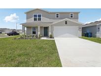 Charming two-story home with a well-maintained lawn and a two car garage at 3508 Dahlia Dr, Haines City, FL 33844