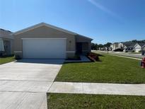 Charming single-story home featuring a well-maintained lawn and a two-car garage at 2374 Aquiline Nest St, Eagle Lake, FL 33839