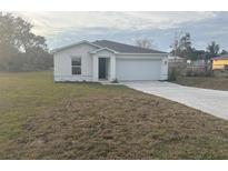 White house with a garage and spacious yard at 2322 Sw 146Th Loop, Ocala, FL 34473