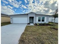 Newly constructed one-story home featuring a two-car garage and well-manicured lawn at 1635 Texas Ave, Sumterville, FL 33585