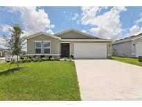 Charming single-story home featuring a two-car garage, well-maintained lawn, and fresh landscaping at 4323 Periwinkle Pl, Lake Hamilton, FL 33851