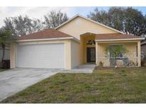 One-story house with attached garage and landscaped lawn at 2325 Paulette Dr, Haines City, FL 33844