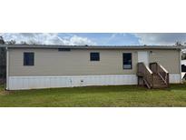 Exterior shot of manufactured home showing siding, stairs to front door, and front lawn at 3123 Crystal Hills Dr, Lakeland, FL 33801