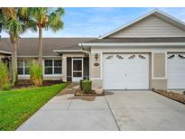Inviting home exterior features a well-manicured lawn and attached two-car garage at 26922 White Plains Way, Leesburg, FL 34748