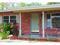 Charming brick home featuring a stylish front door, tiled porch and well maintained landscaping at 5801 Poinciana Ave, Lakeland, FL 33809