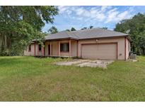 Single story home showing the front porch and attached garage in a lush green yard at 18829 Starry St, Orlando, FL 32833