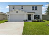 Charming two-story home with a well-manicured lawn and a two car garage in a suburban neighborhood at 2222 Oklahoma Dr, Sumterville, FL 33585