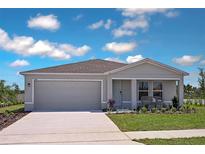 Charming single-story home featuring a two-car garage, well-manicured lawn, and inviting front porch at 2383 Oklahoma Dr, Sumterville, FL 33585