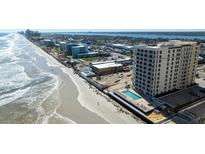 Oceanfront view of a residential condo building with a swimming pool and beach access at 2071 S Atlantic Ave # 201, Daytona Beach Shores, FL 32118