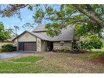 Charming home with stone accents, a well-maintained lawn, and a two car garage with ample driveway space at 100 Longspur Ct, Daytona Beach, FL 32119