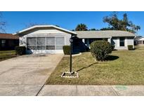 Charming single-story home with a well-maintained lawn and a screened-in garage on a sunny day at 305 American Way, Daytona Beach, FL 32119