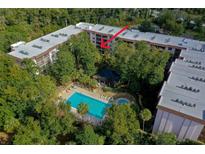 A tranquil aerial view of the community pool area and lush landscaping surrounding the condos at 640 N Nova Rd # 212, Ormond Beach, FL 32174