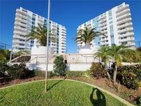 Condominium buildings with multiple balconies surrounded by tropical landscaping and green grass at 935 N Halifax Ave # 602, Daytona Beach, FL 32118