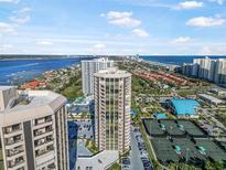 Aerial view of condo building with ocean and city views, tennis courts, and pool at 1 Oceans West Blvd # 16A4, Daytona Beach Shores, FL 32118