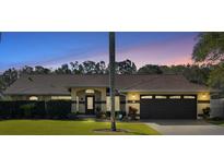 Inviting house exterior featuring a landscaped lawn and a two-car garage at 10 Ocean Pines Dr, Ormond Beach, FL 32174