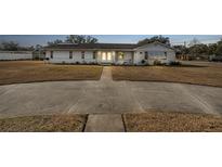 Ranch-style home with brick facade, solar panels, and a large yard at 1102 Rolling Acres Dr, Deland, FL 32720